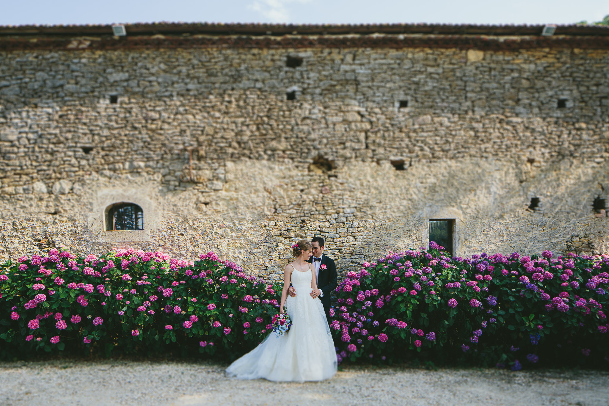 French professional wedding photographer gorgeous married couple in front of a bush of pink hydrangeas 