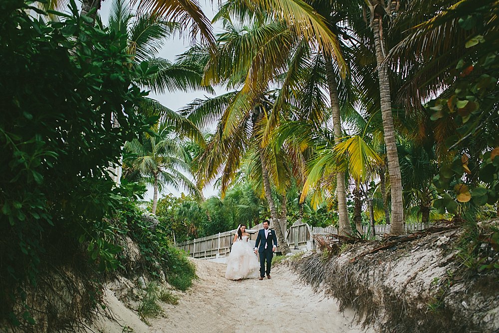 Bahamian wedding bride and groom walking to beach portrait