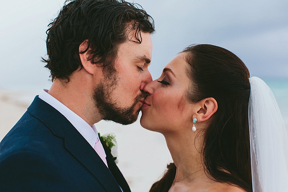 Bahamian wedding bride and groom kiss each other on the beach