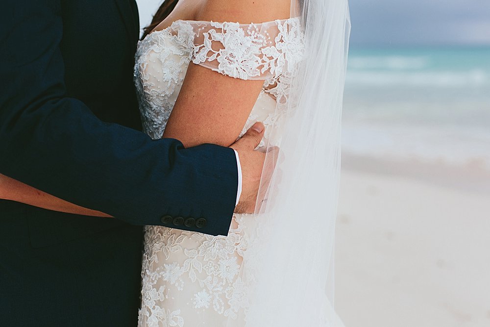 Bahamian wedding bride and groom holding each other closely on the beach