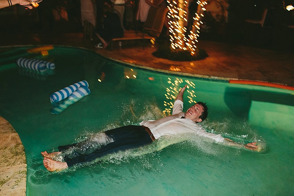 Bahamian wedding groomsman in swimming pool
