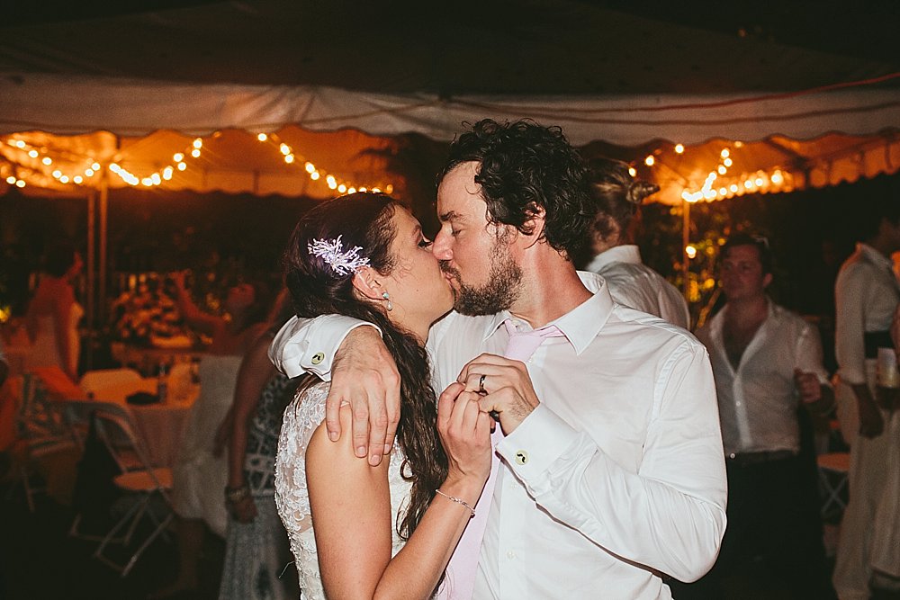 Bahamian wedding groom and his bride party kiss