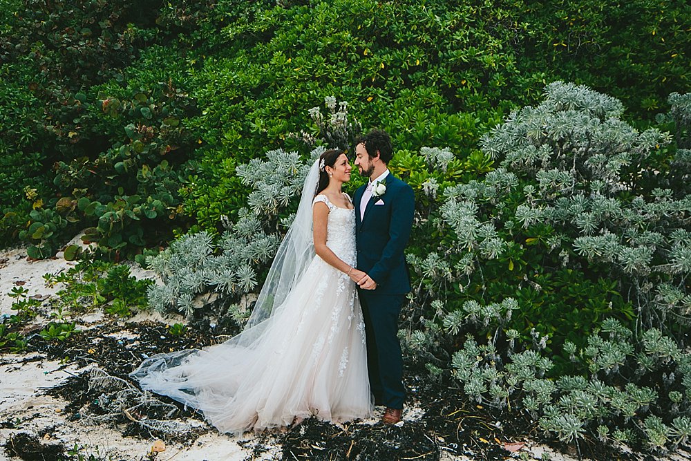 Bahamian wedding bride and groom green foliage beach