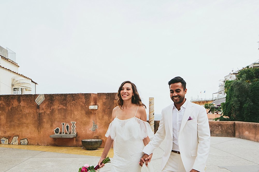 Happy bride and groom walking in Positano