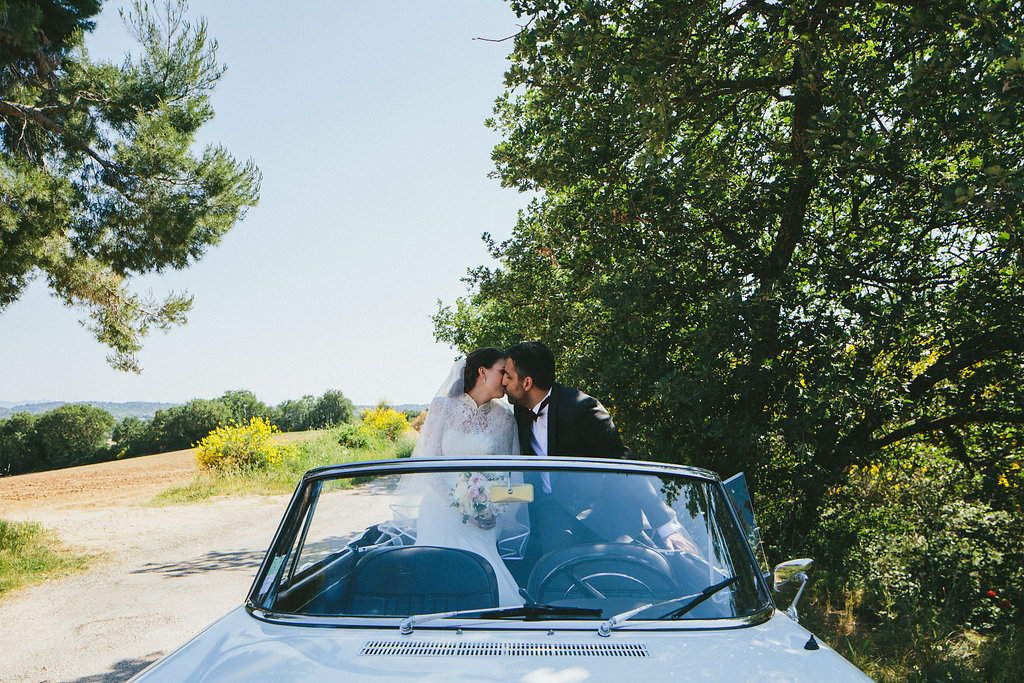 Provence wedding Bride and Groom kissing back of a Peugeot 404