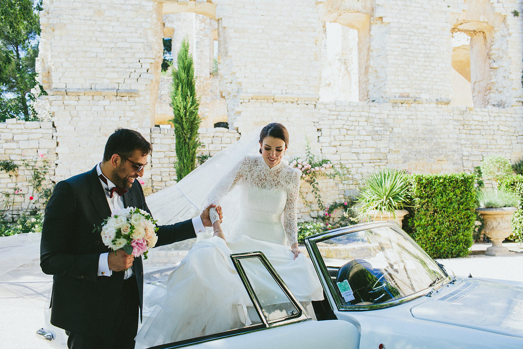 groom helping bride of a car