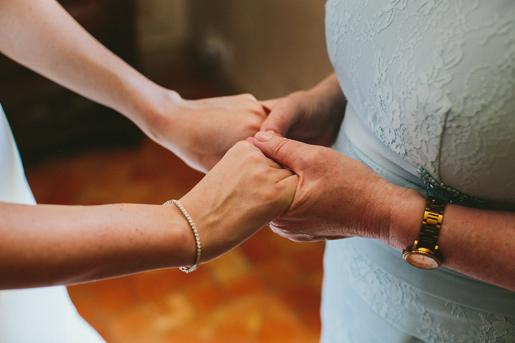 bride and mother of the bride holding hands