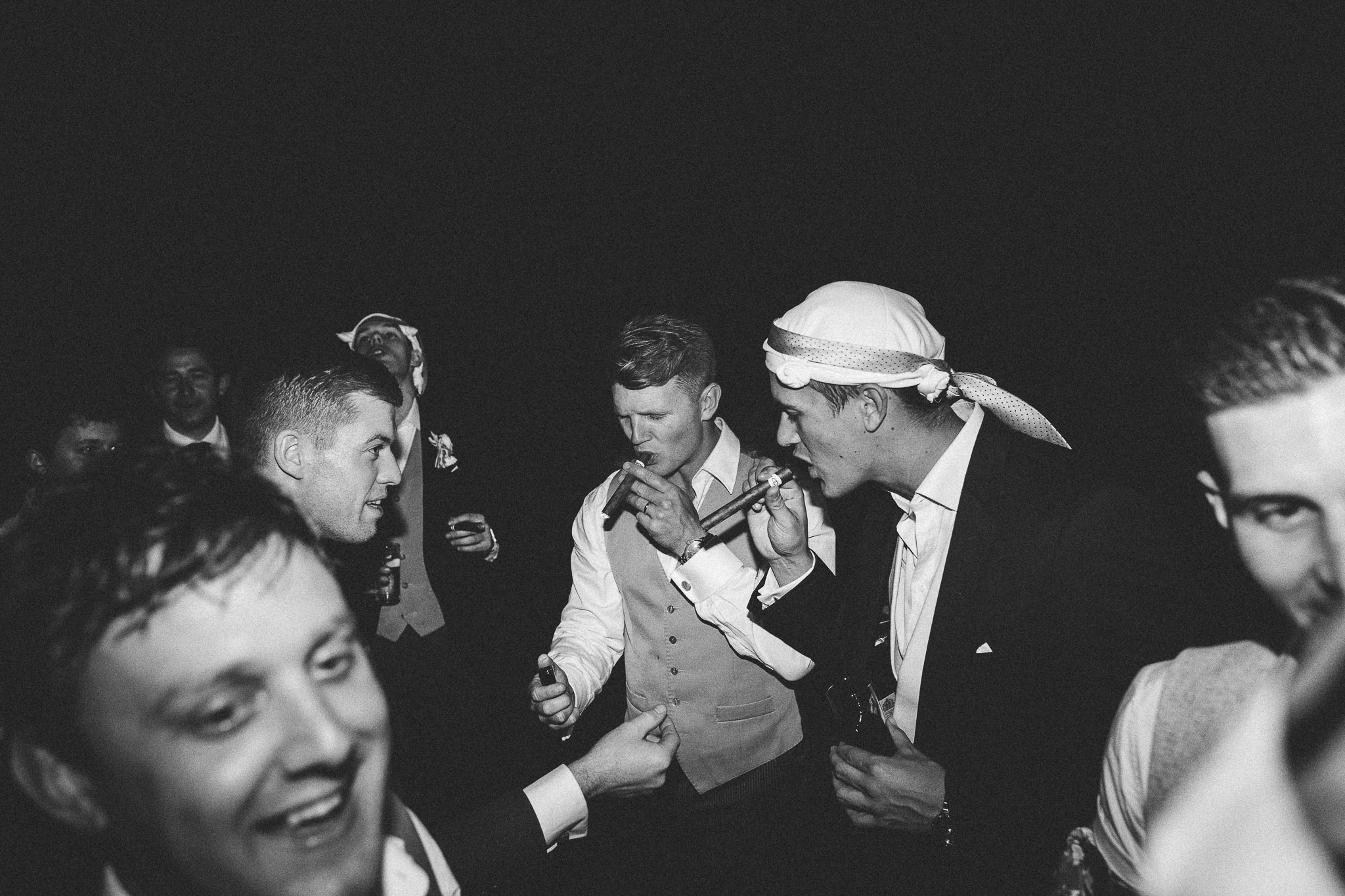 A french destination wedding groom and groomsman smoking cigars