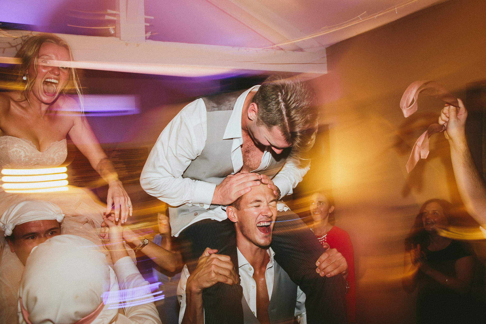 bride and groom on friends shoulders party time french wedding