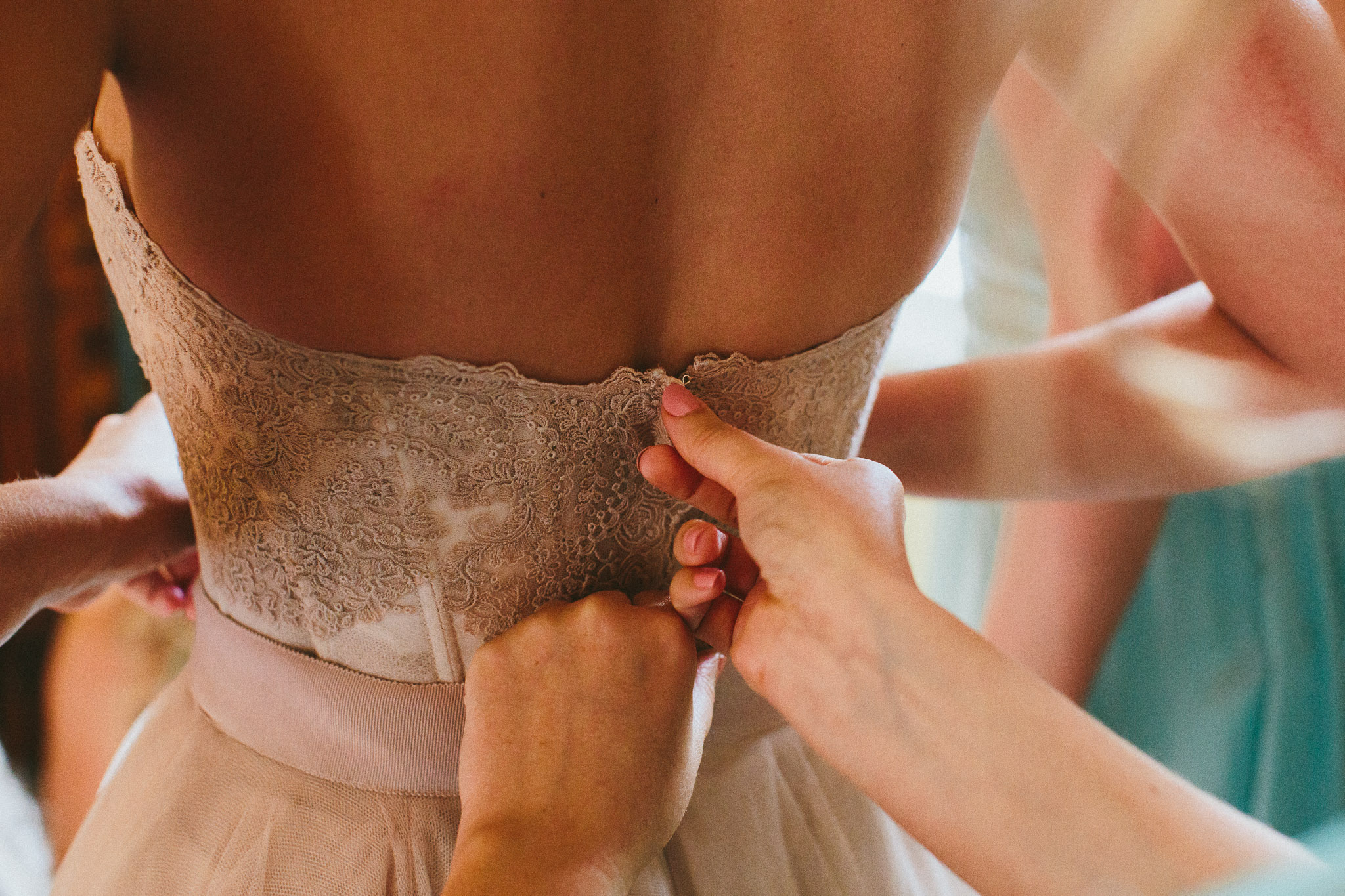 A french destination wedding bride getting into her wedding dress