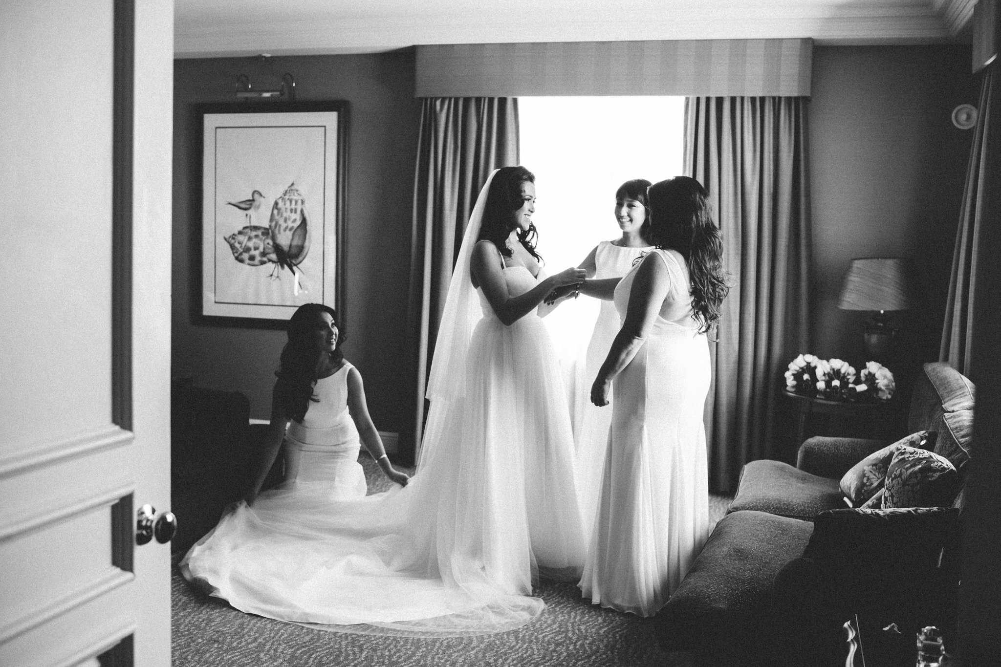 Bridesmaids helping bride get ready