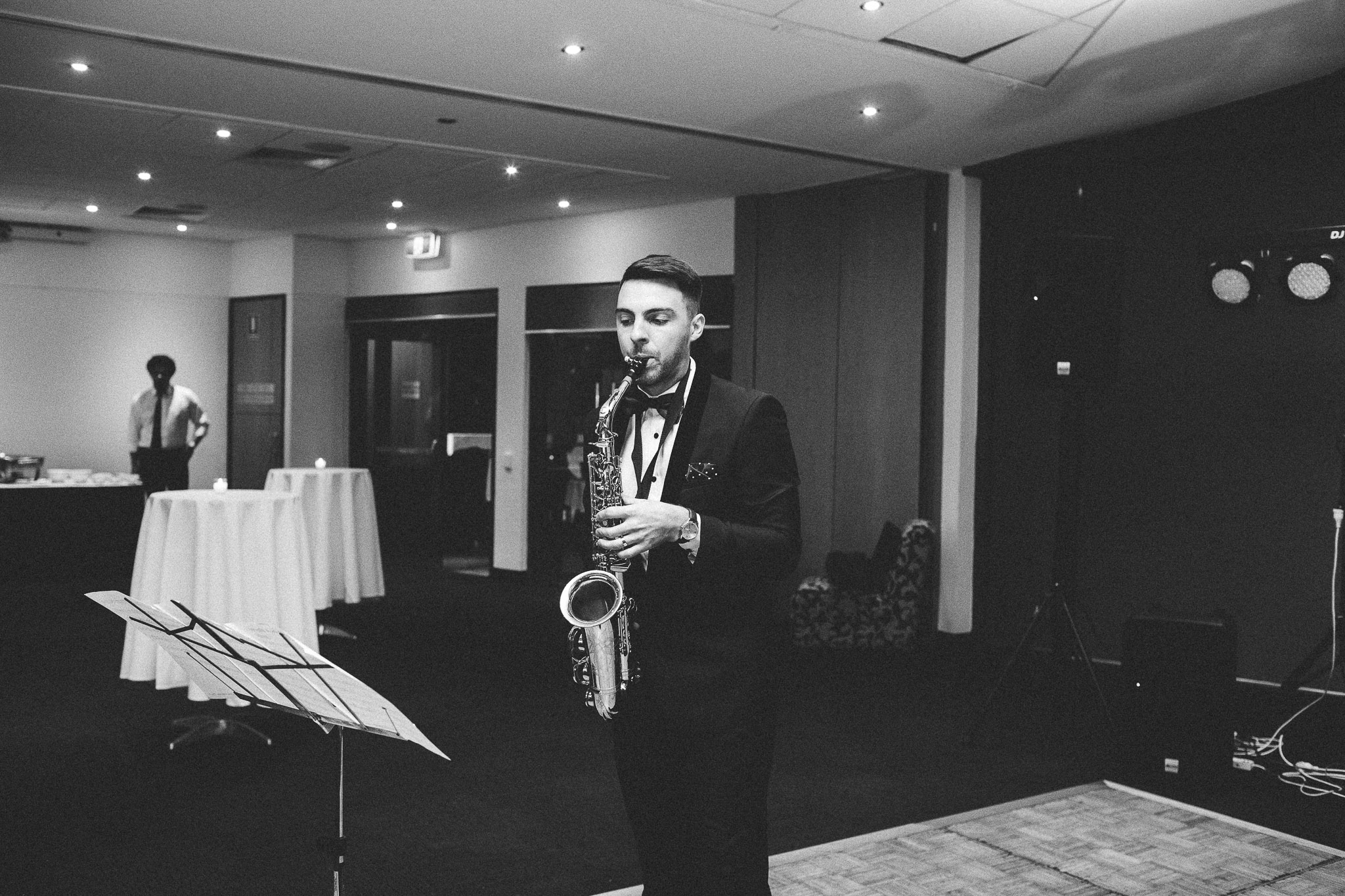 groom playing saxophone at his reception
