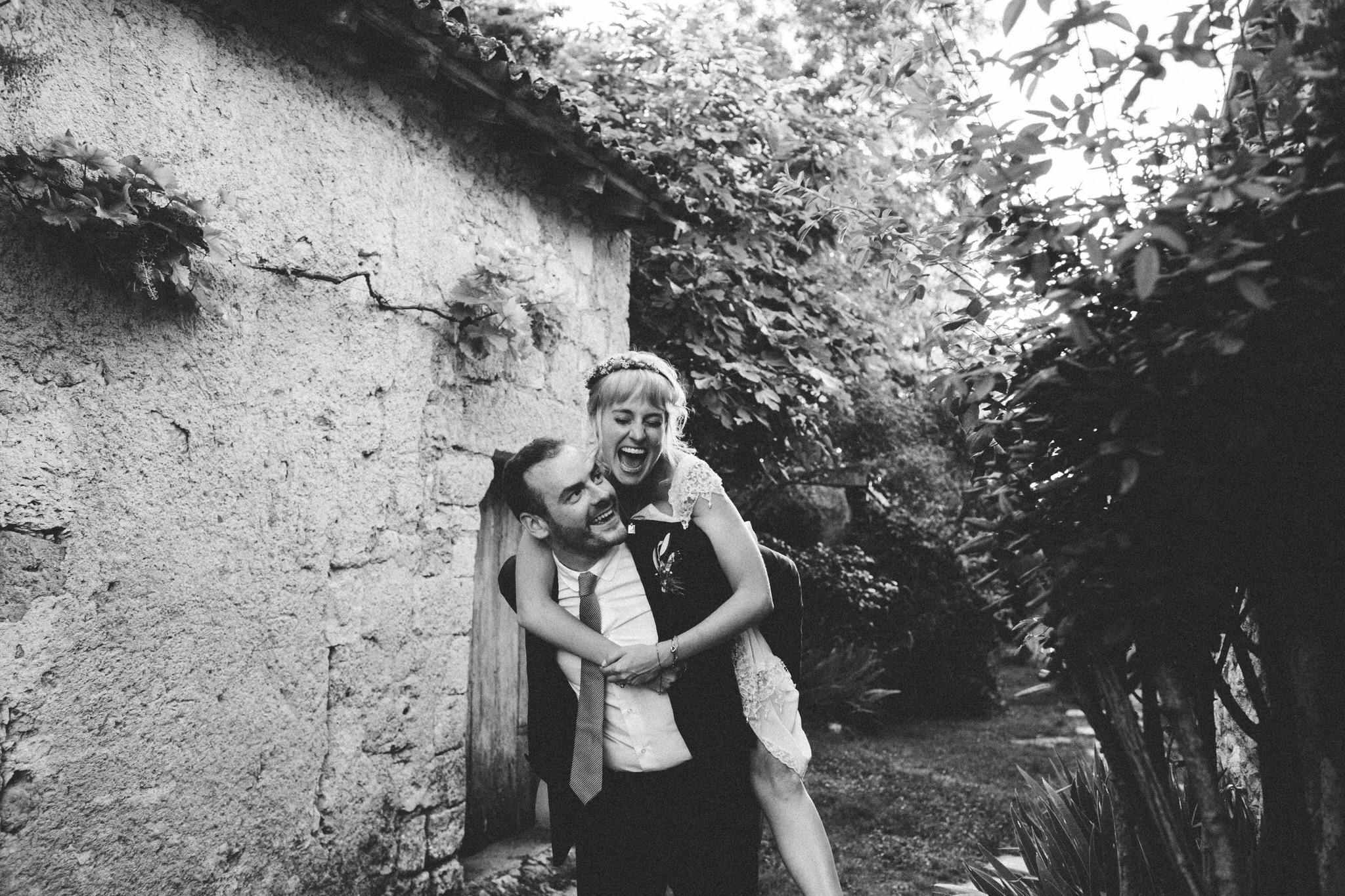 groom giving piggyback ride to bride laughs