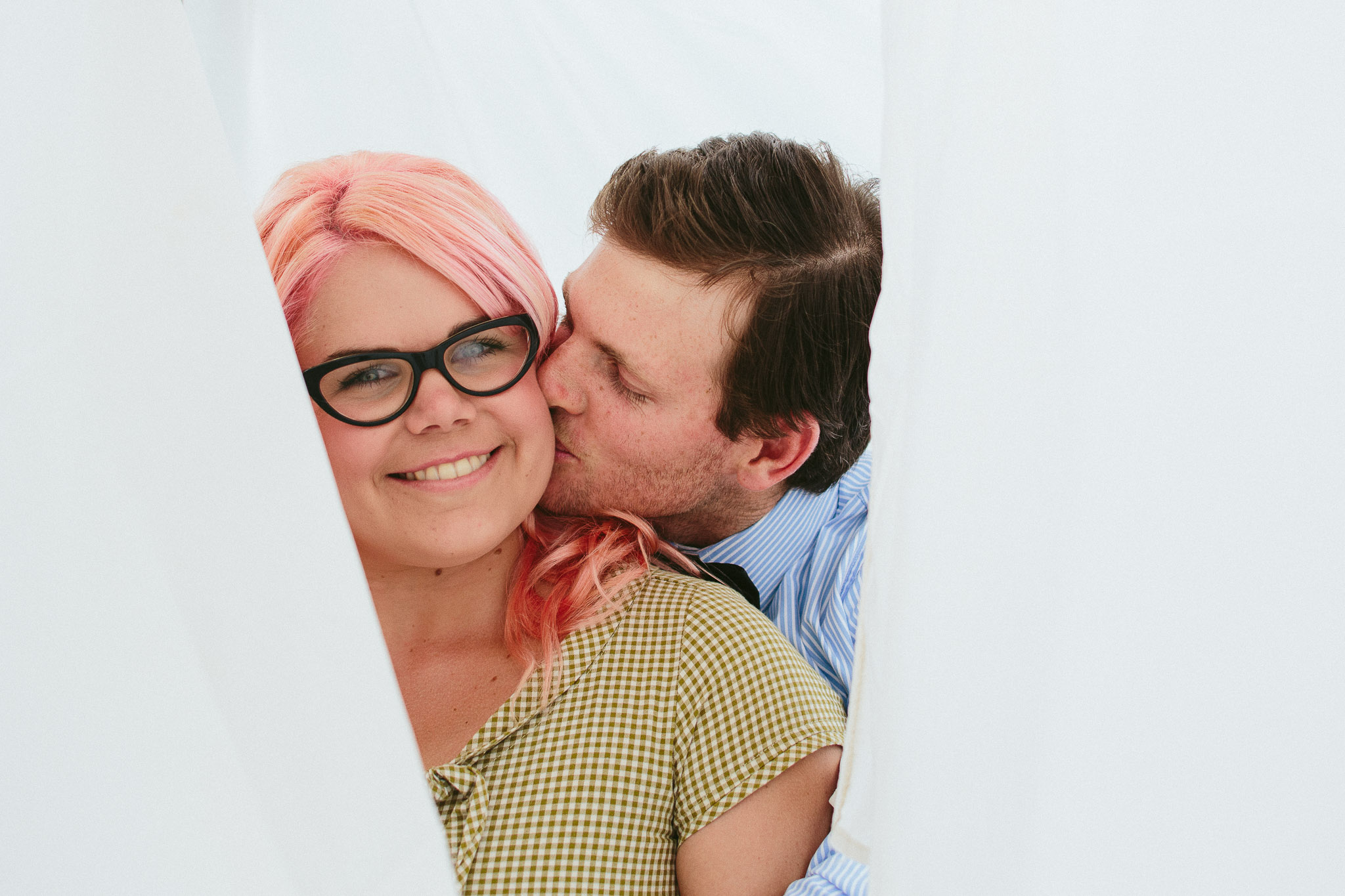engagement photos couple in sheets kiss