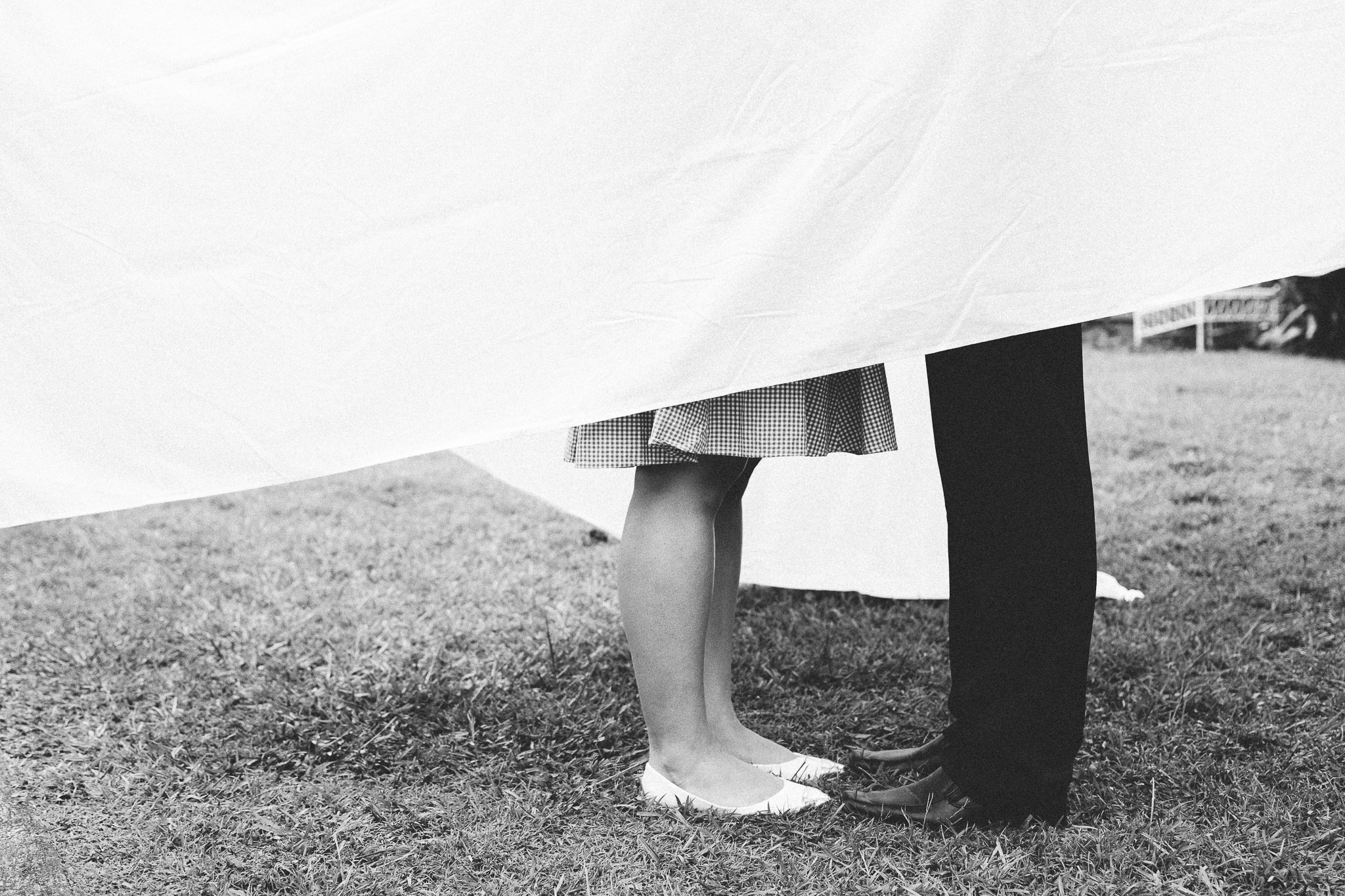 engagement couple hugging behind sheets feet
