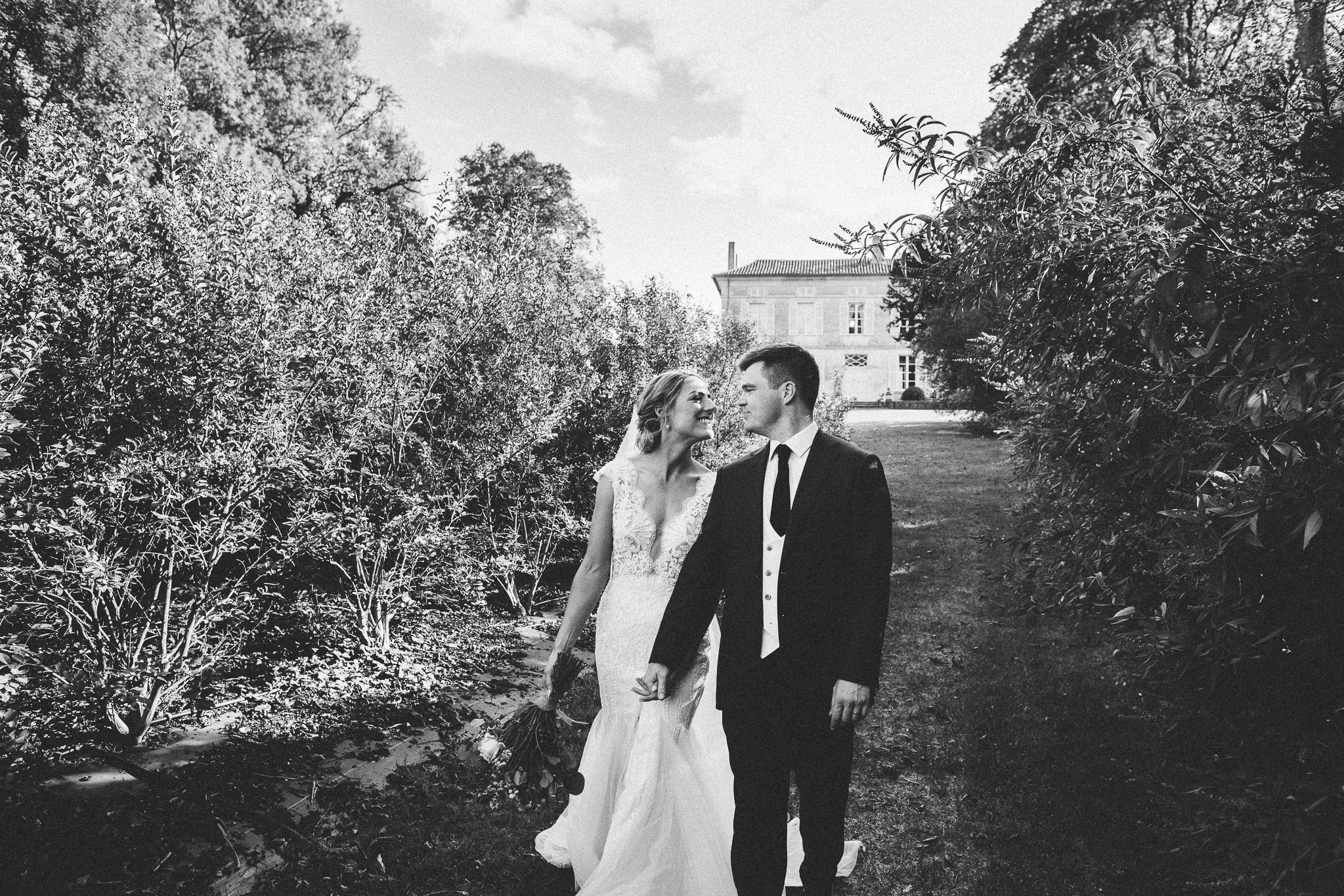 photo session portrait bride and groom walking french domaine in background 