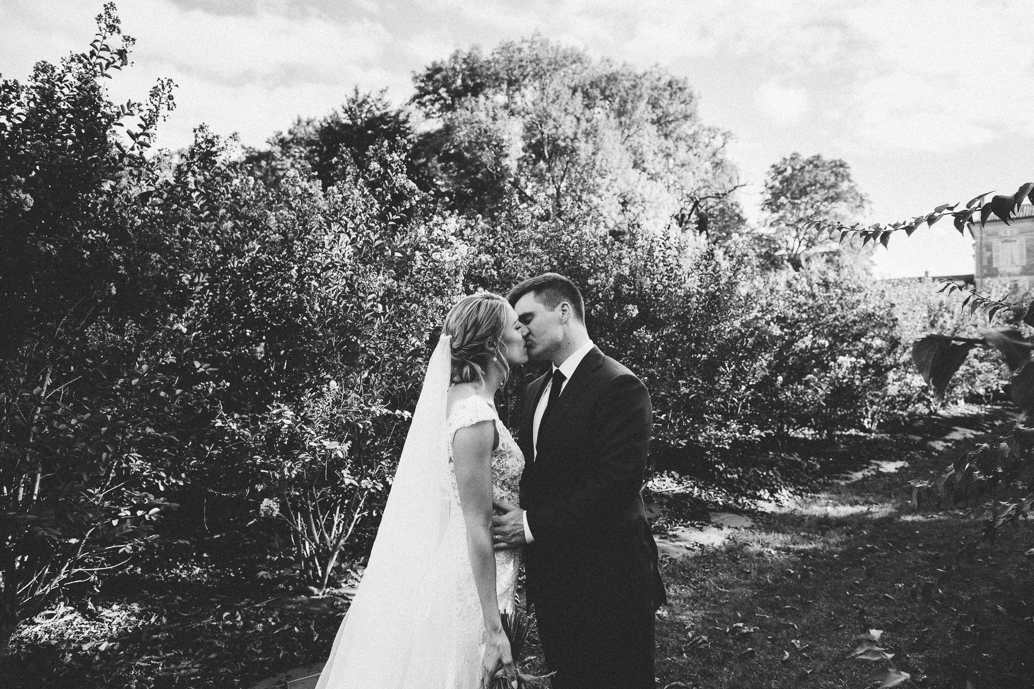 wedding photo session portrait bride and groom kissing french domain in background