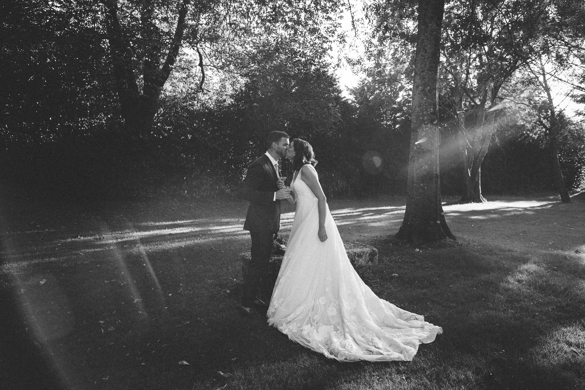photo summary bride and groom kissing in sunlight