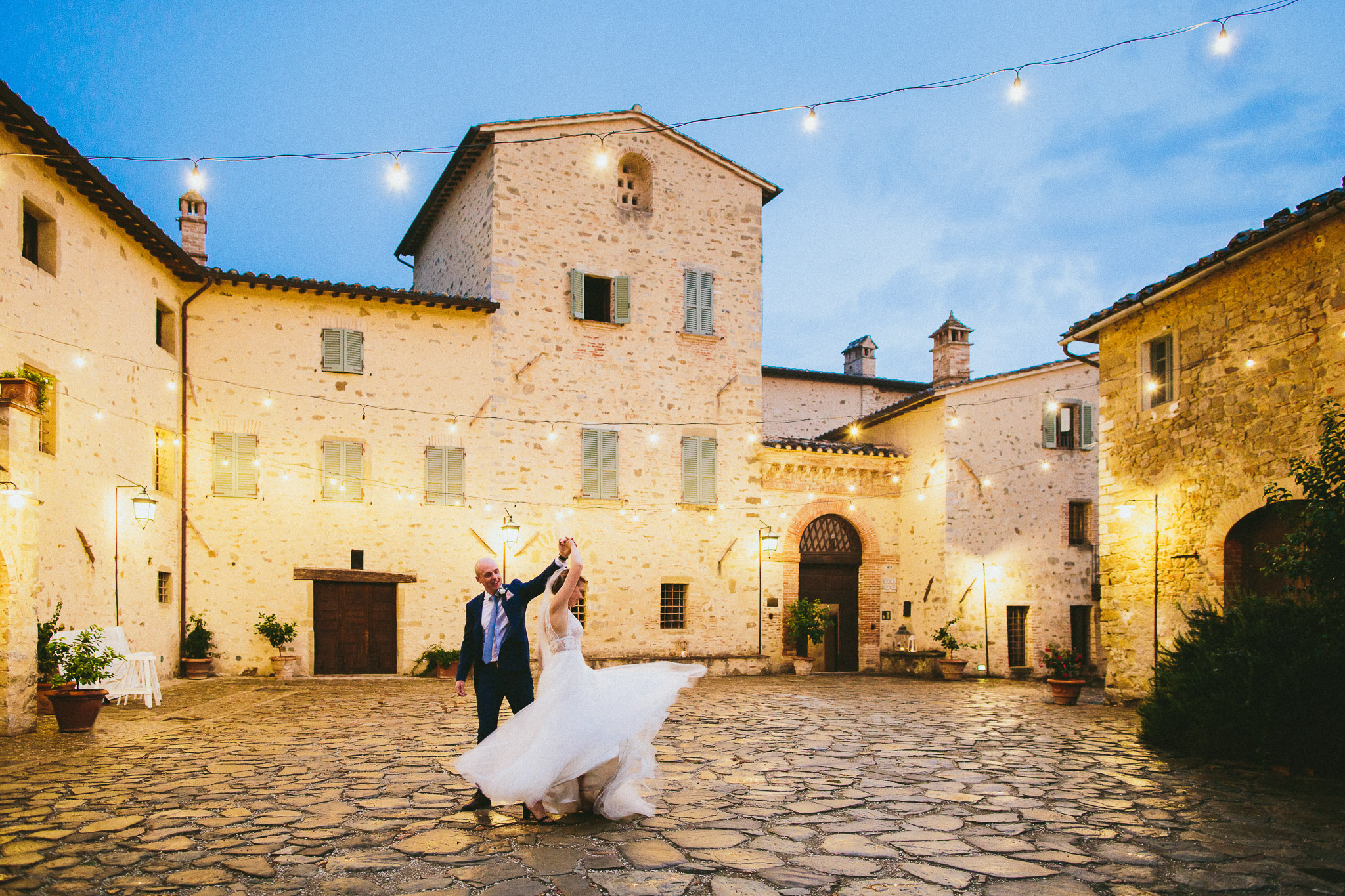 bride and groom dancing in a square in italy