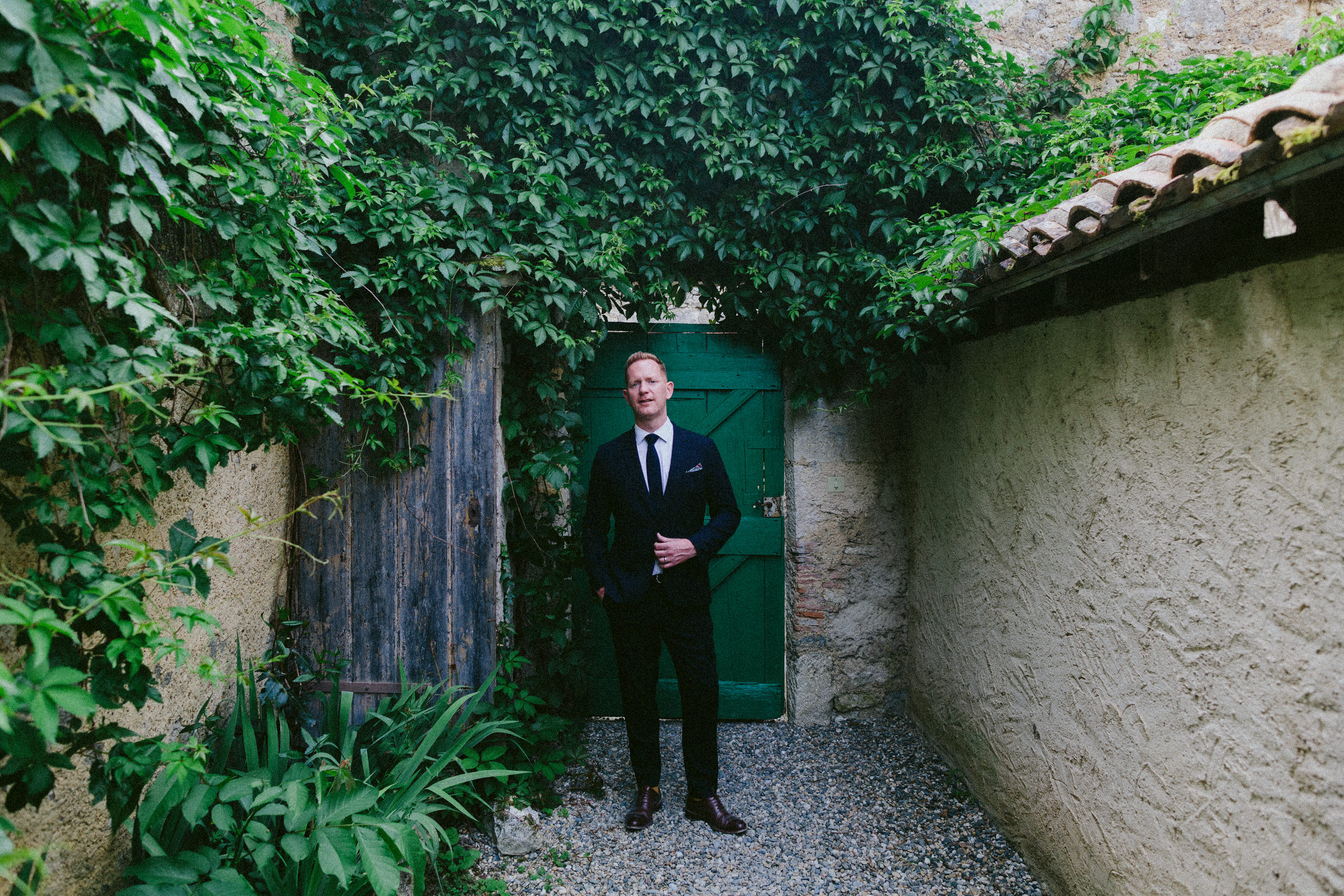 portrait of a groom green door Castelnau des Fieumarcon french village wedding